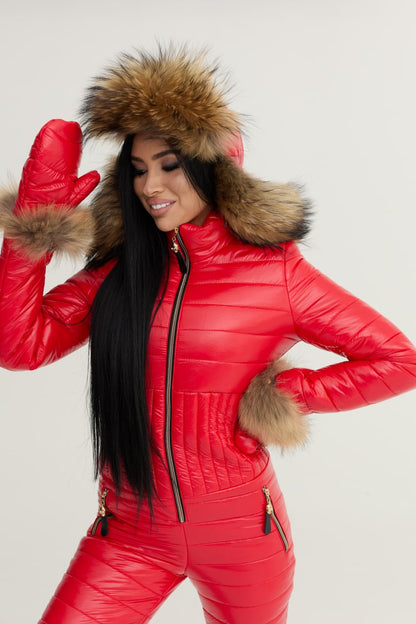 Person wearing a red puffer suit with fur hood and cuffs on a light gray background