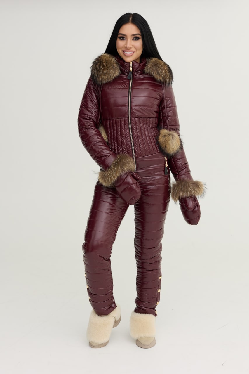 Woman wearing a burgundy winter suit with fur trim on a white background