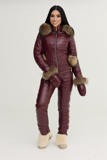 Woman wearing a burgundy winter suit with fur trim on a white background