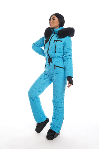 Person wearing a blue snowsuit with black fur trim on a white background