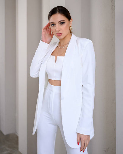 Woman wearing a white outfit against a neutral background