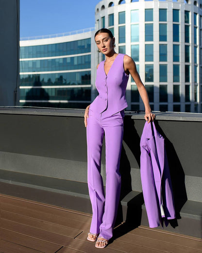 Woman in a purple outfit standing on a rooftop with modern buildings in the background