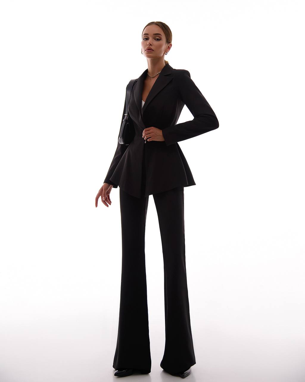 Woman wearing a black suit on a white background