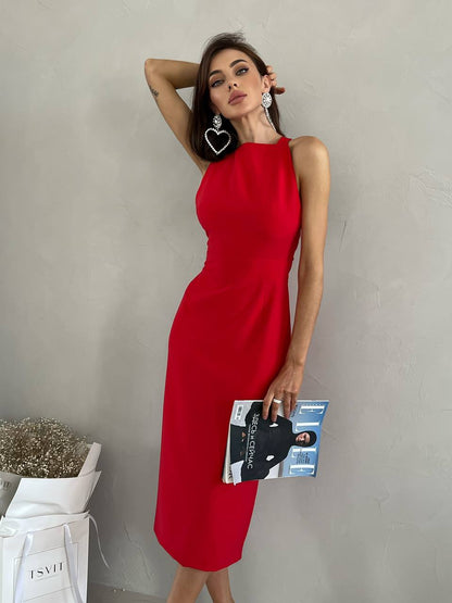 Woman in a red dress holding a magazine against a plain background
