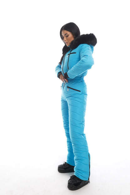 Person wearing a blue snowsuit with black boots on a white background