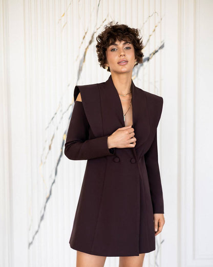 Woman wearing a dark brown blazer dress against a white background