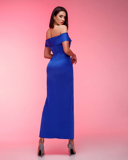 Woman wearing a blue off-shoulder dress against a pink background