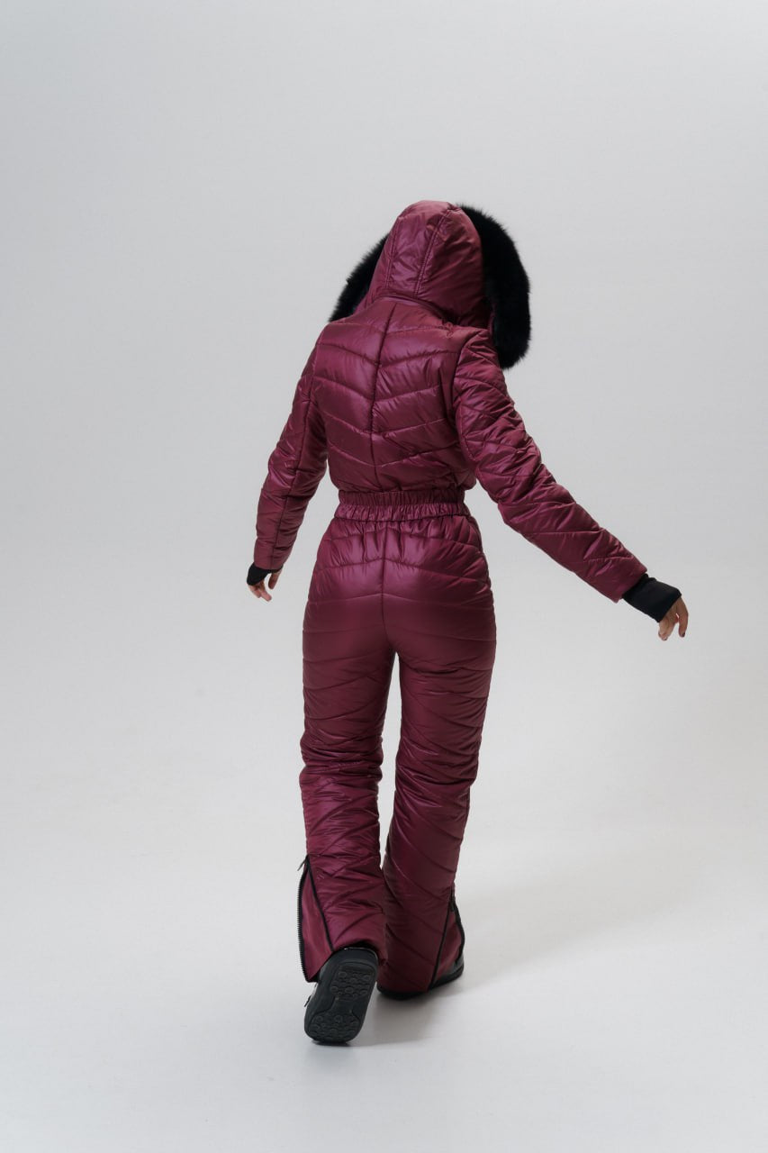 Person wearing a purple puffer suit on a white background