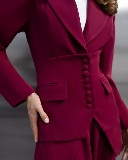 Close-up of a burgundy suit with buttons on a neutral background