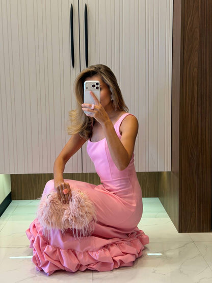 Woman in a pink dress taking a mirror selfie in an indoor setting.