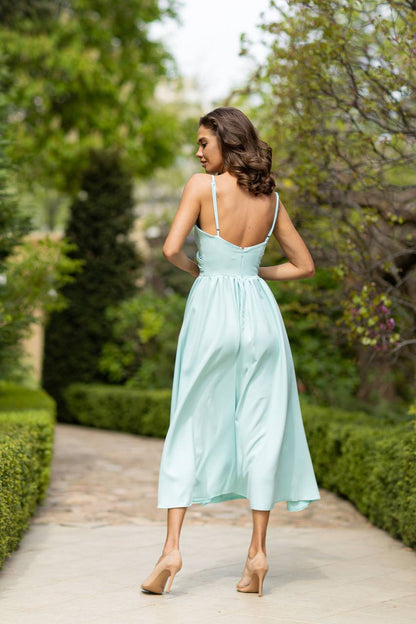 Woman in a light blue dress walking through a garden
