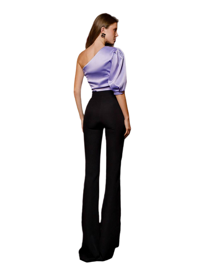 Woman wearing a one-shoulder purple top and black pants on a white background