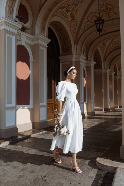 Woman in a white dress standing in an elegant architectural setting