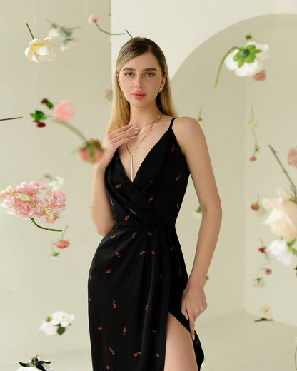 Woman wearing a black dress with floral patterns against a floral background