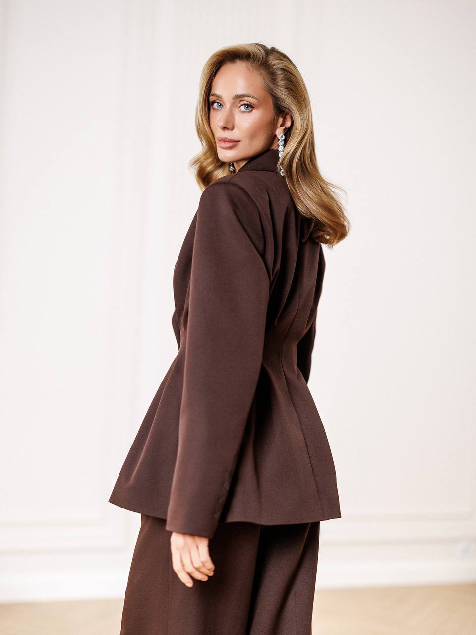 Woman wearing a brown outfit against a white background