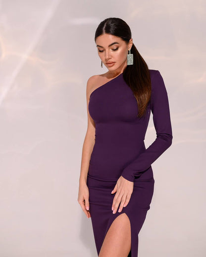 Woman wearing a purple one-shoulder dress with a slit on a light background