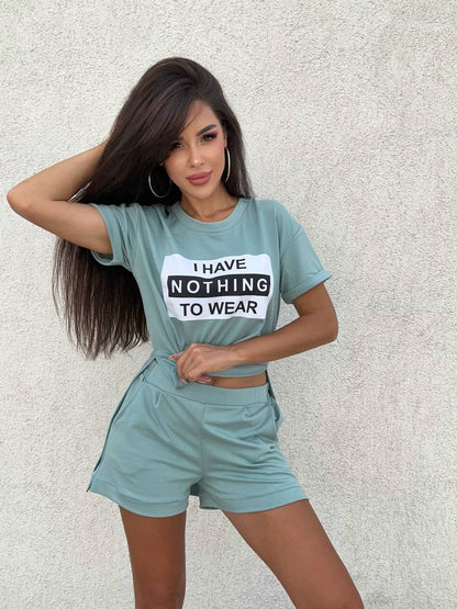 Woman wearing a teal outfit with a shirt that says 'I have nothing to wear' against a light background