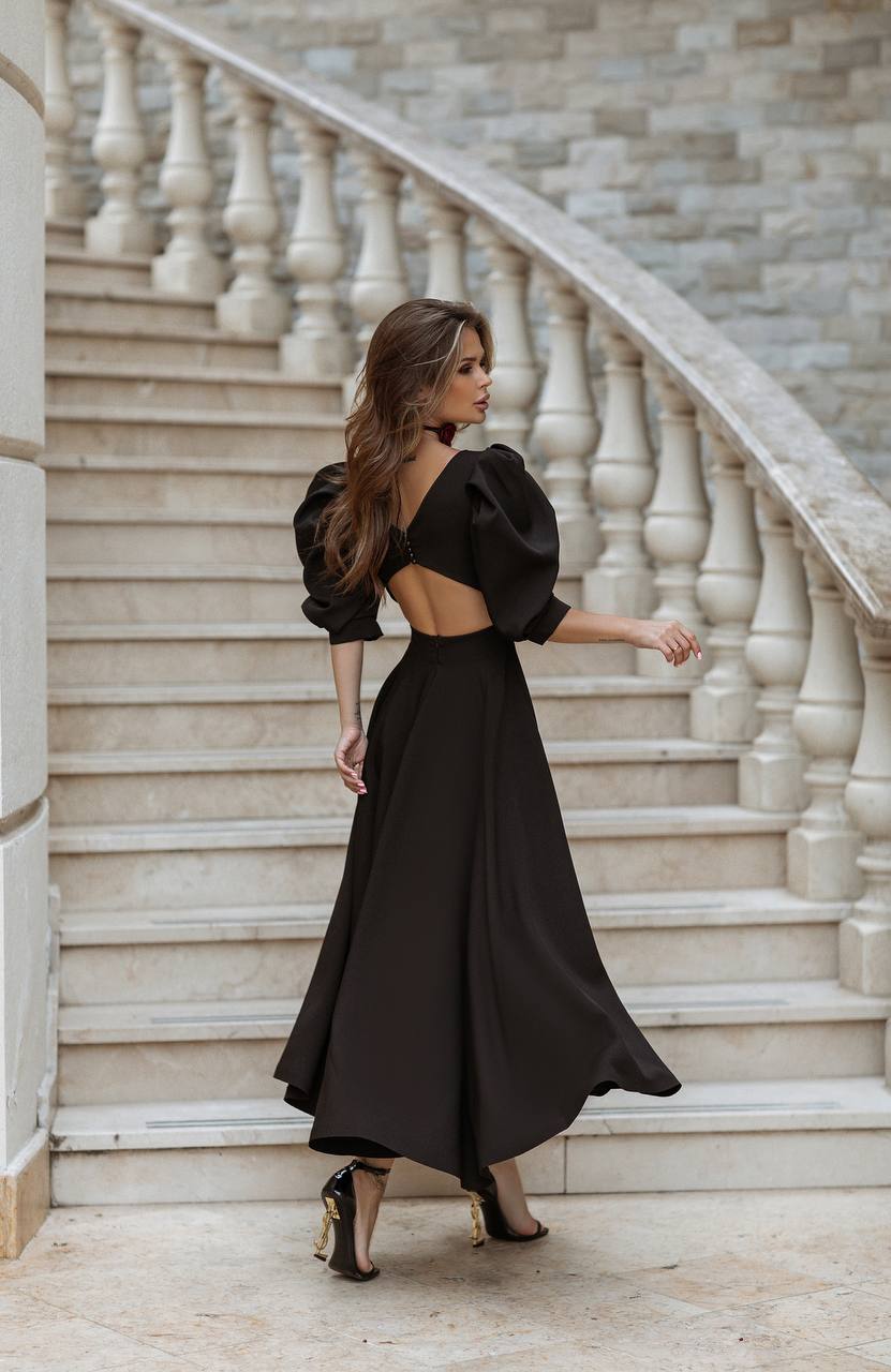 Woman in a black dress standing on a marble staircase