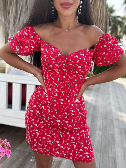 Woman wearing a red floral dress with a blurred outdoor background