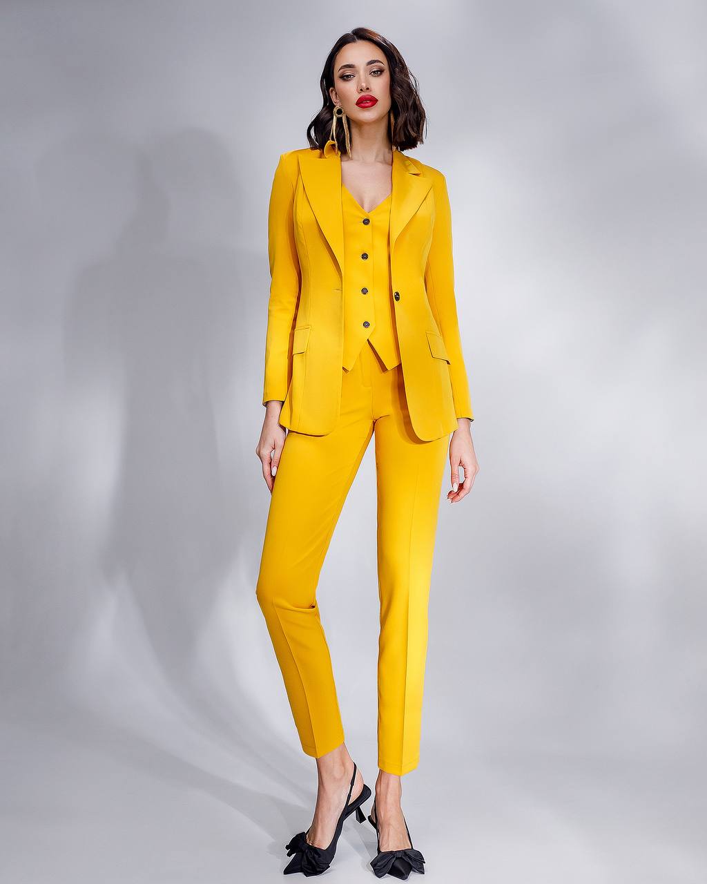 Woman wearing a yellow suit on a gray background