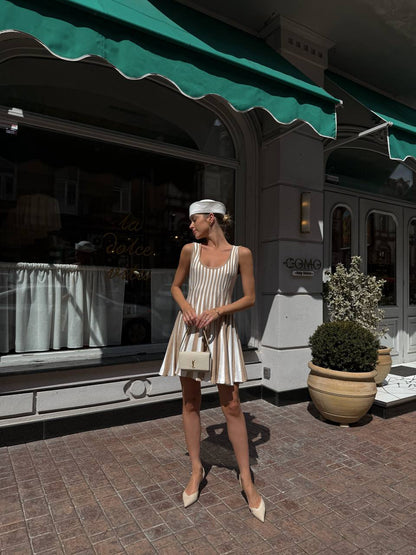 Woman in a white dress standing in front of a store with a green awning.