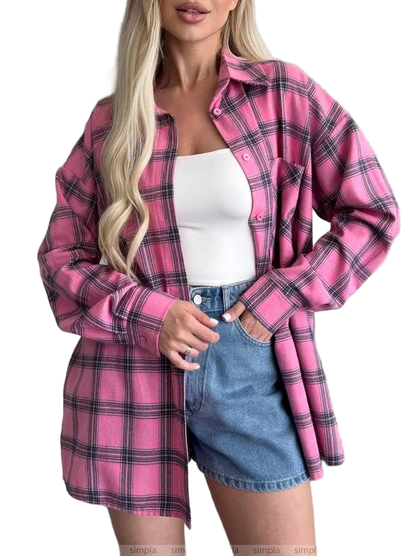 Woman wearing a pink plaid shirt over a white top and denim skirt on a white background