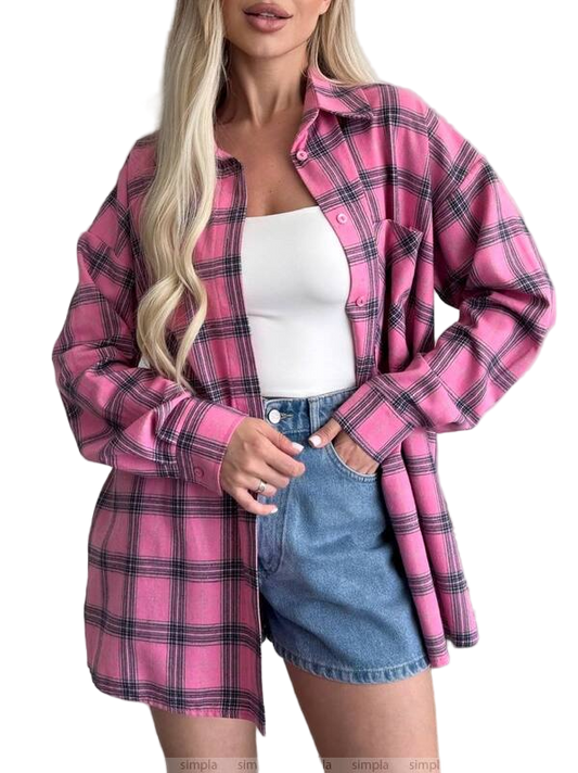 Woman wearing a pink plaid shirt over a white top and denim skirt on a white background