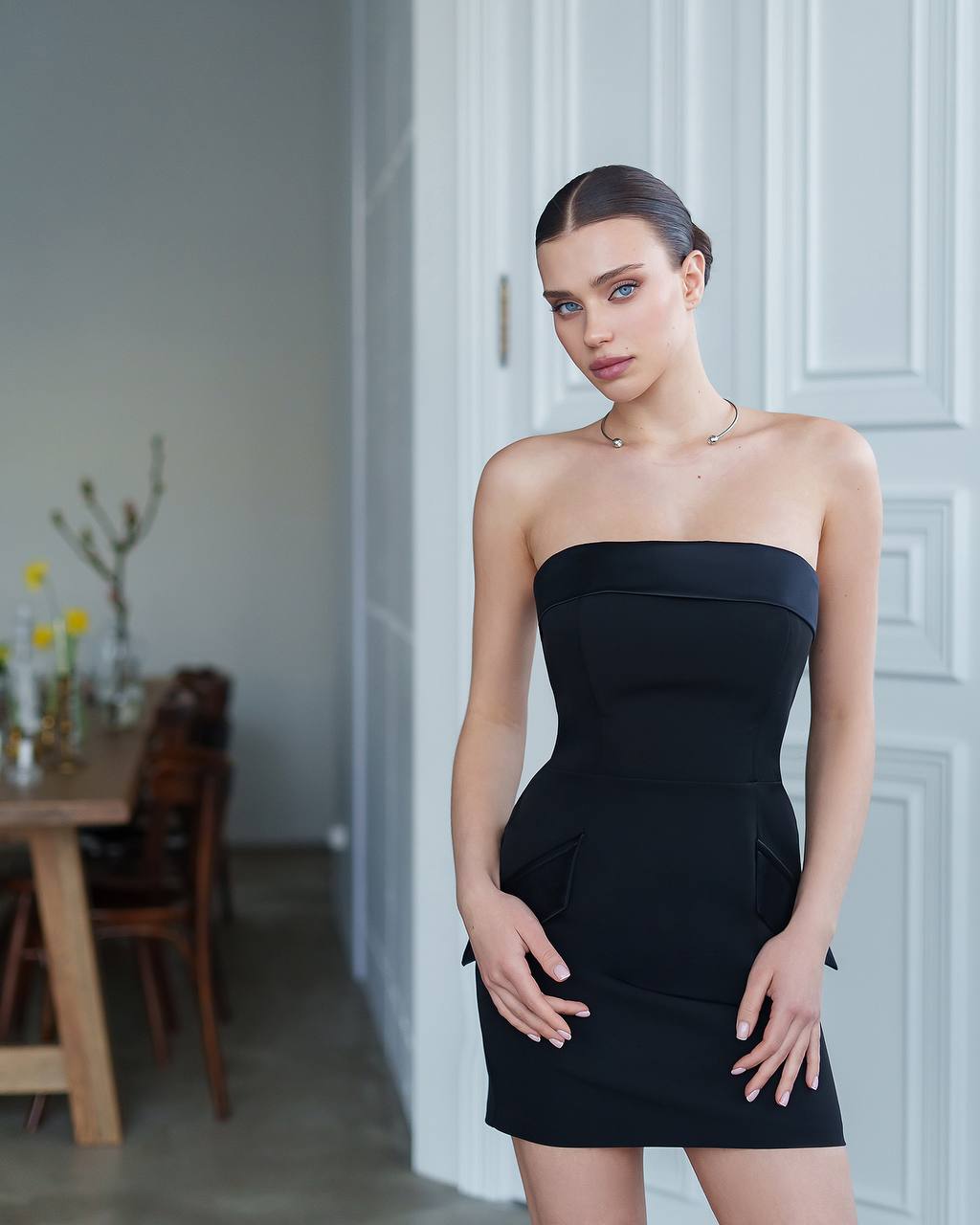 Woman wearing a black strapless dress in an indoor setting