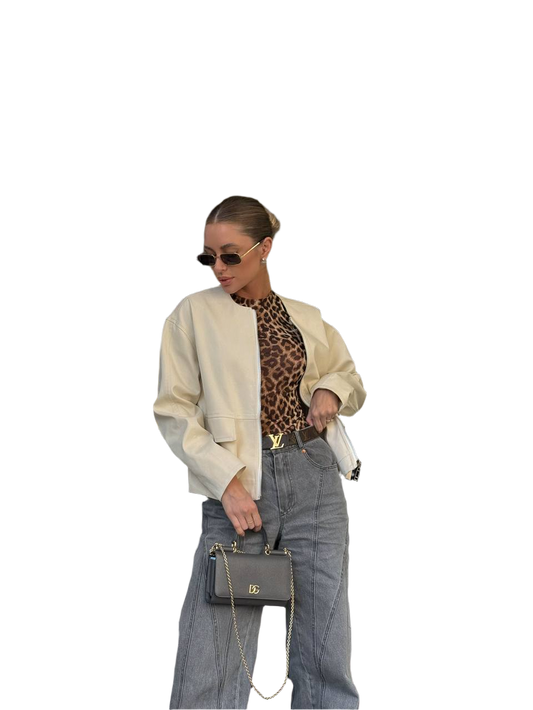 Person wearing a beige cardigan, leopard print top, and gray pants with sunglasses and a handbag on a white background