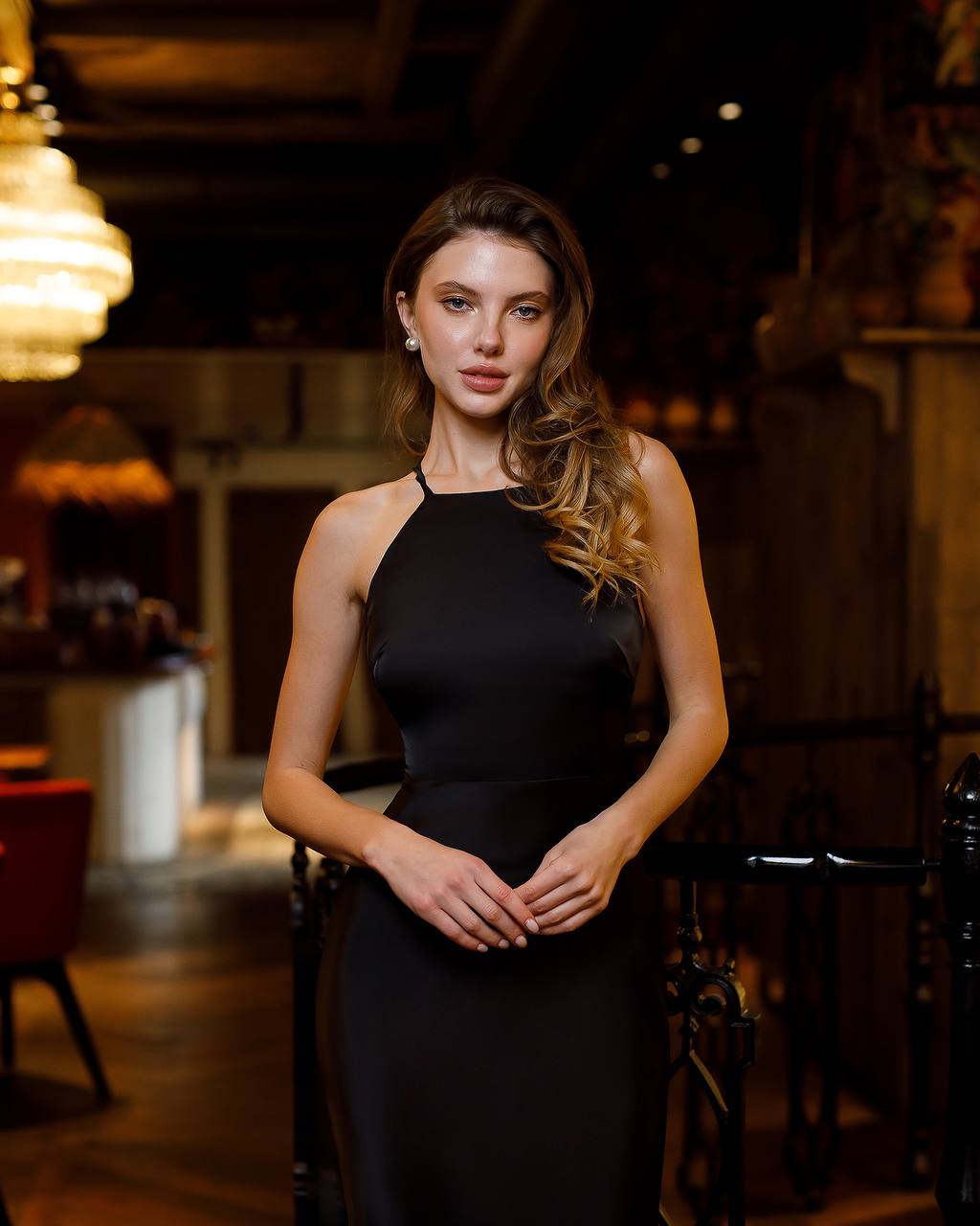 Woman in a black dress standing in an elegant indoor setting
