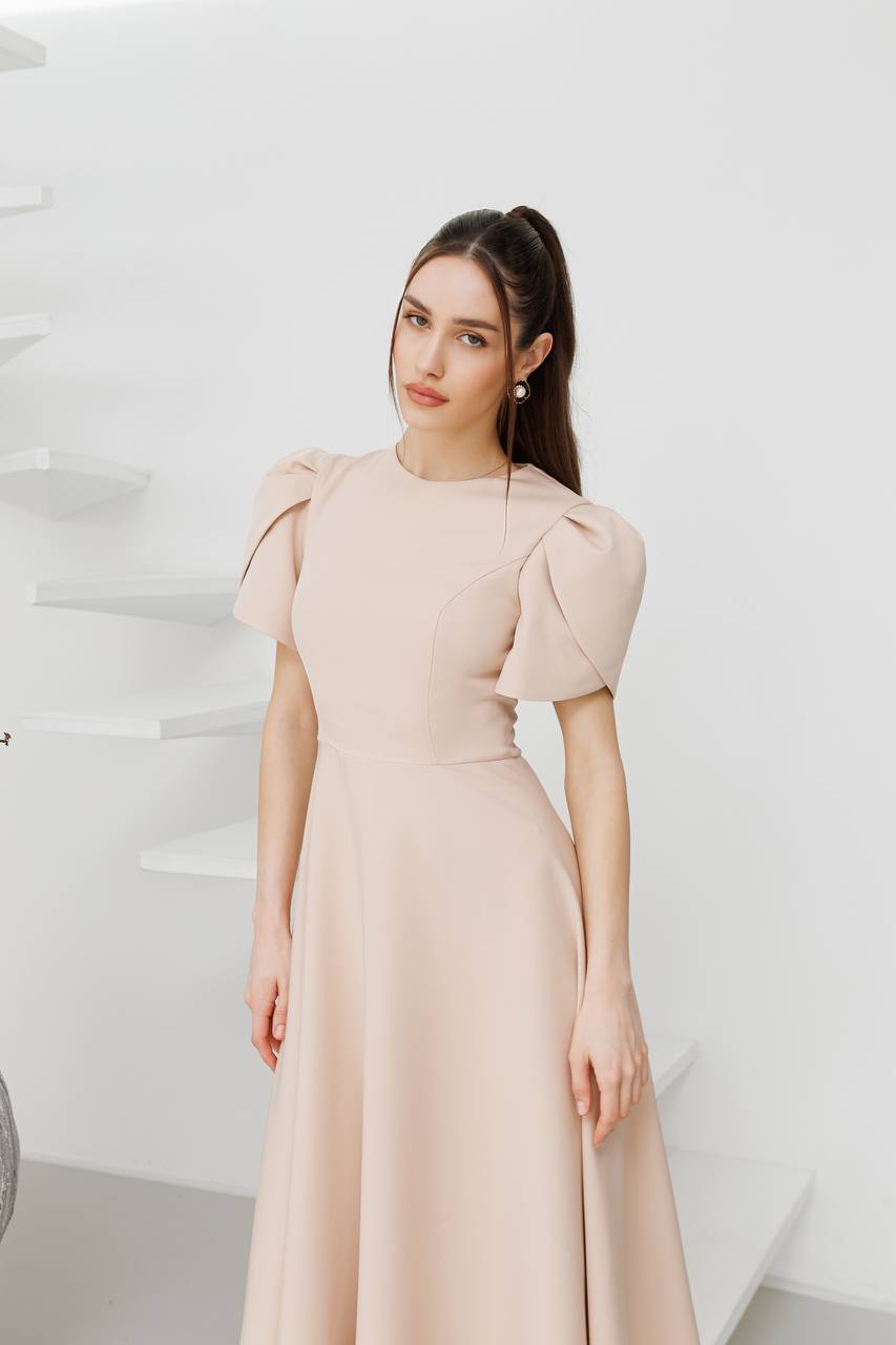 Woman wearing a beige dress against a white background
