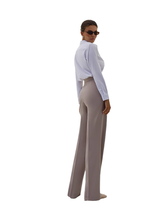 Woman wearing a white blouse and beige pants on a white background