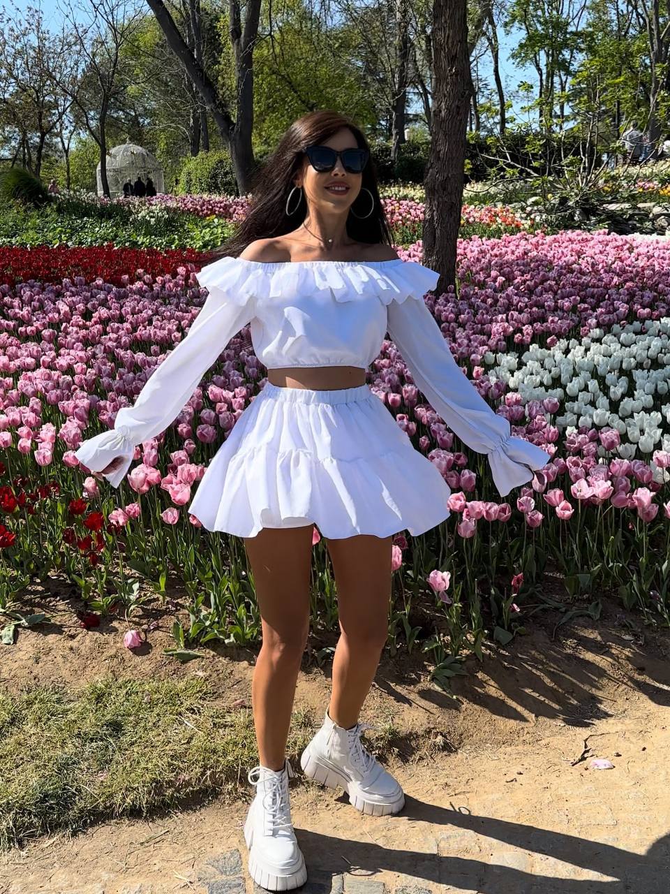 Woman in a white outfit standing in front of tulip flowers