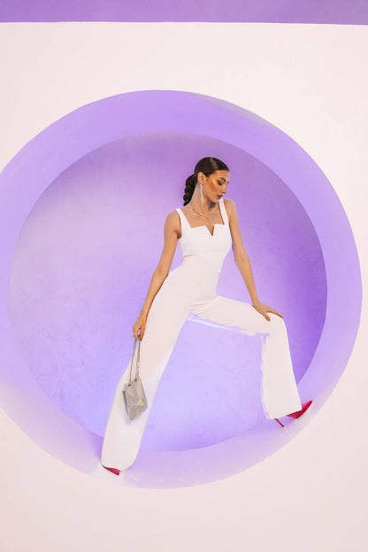 Woman in a white outfit sitting inside a circular purple structure.