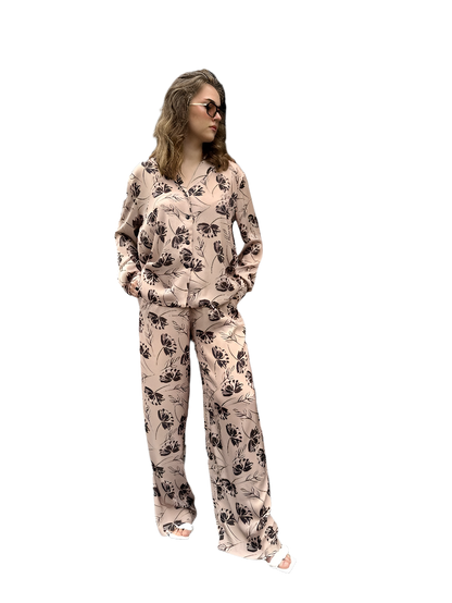 Woman wearing a floral pajama set on a white background