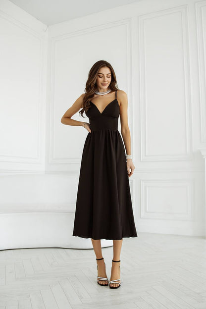 Woman wearing a black dress in a white room