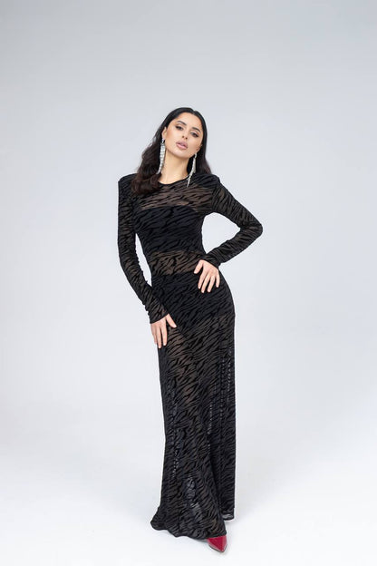 Woman wearing a black patterned dress on a white background