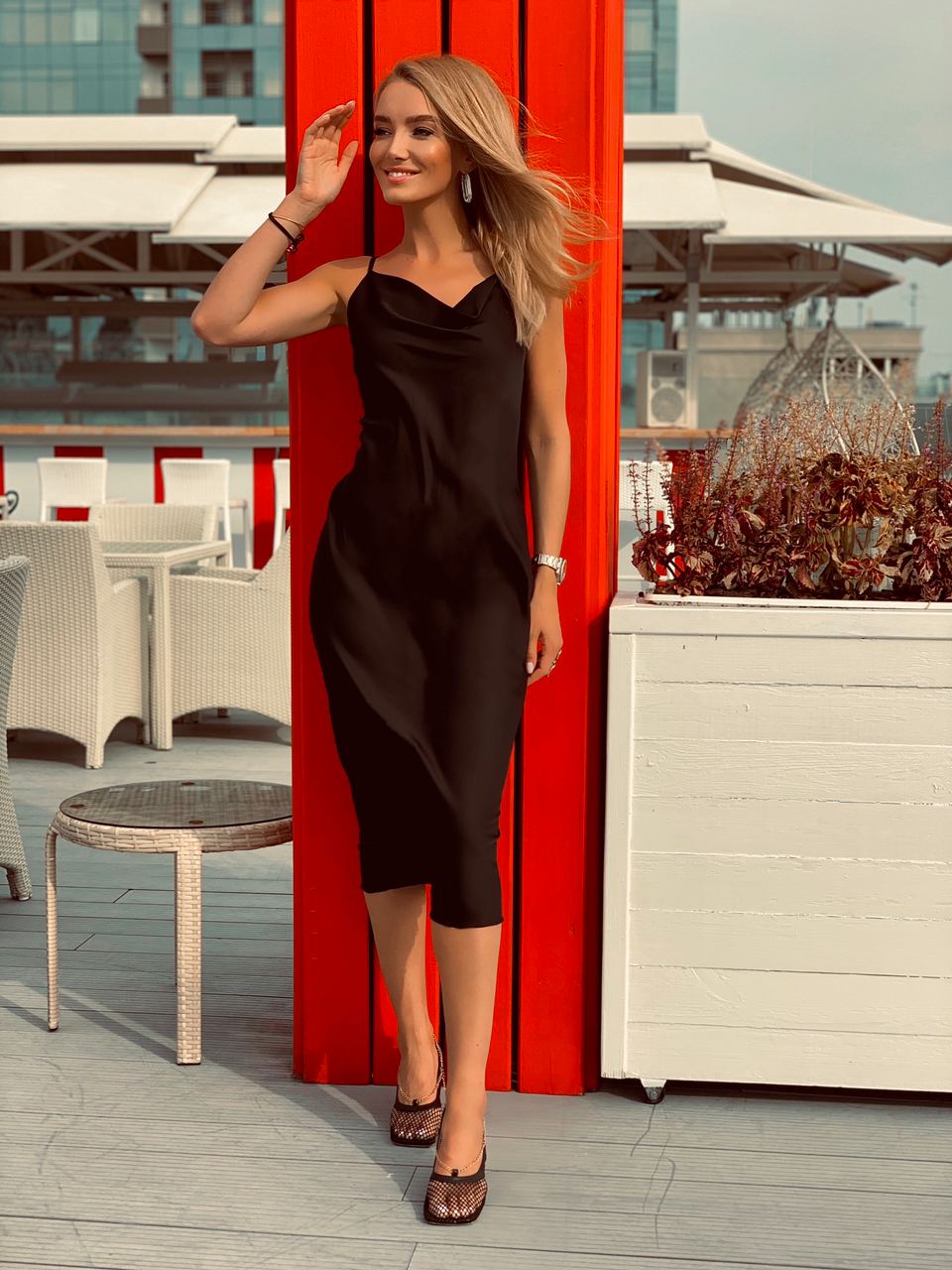 Woman in a black dress standing on a rooftop with red and white decor