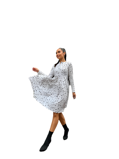 Woman wearing a white dress with black polka dots on a white background