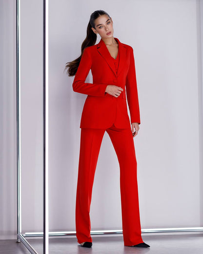 Woman wearing a red suit standing against a white background
