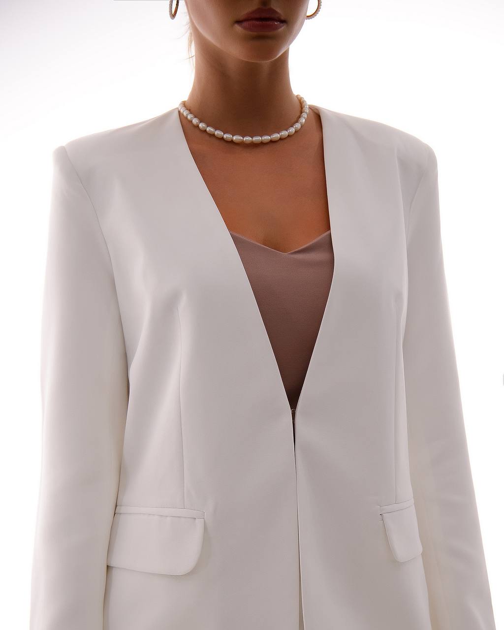 White blazer worn by a person on a white background