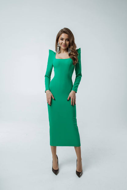 Woman wearing a green dress with long sleeves on a white background