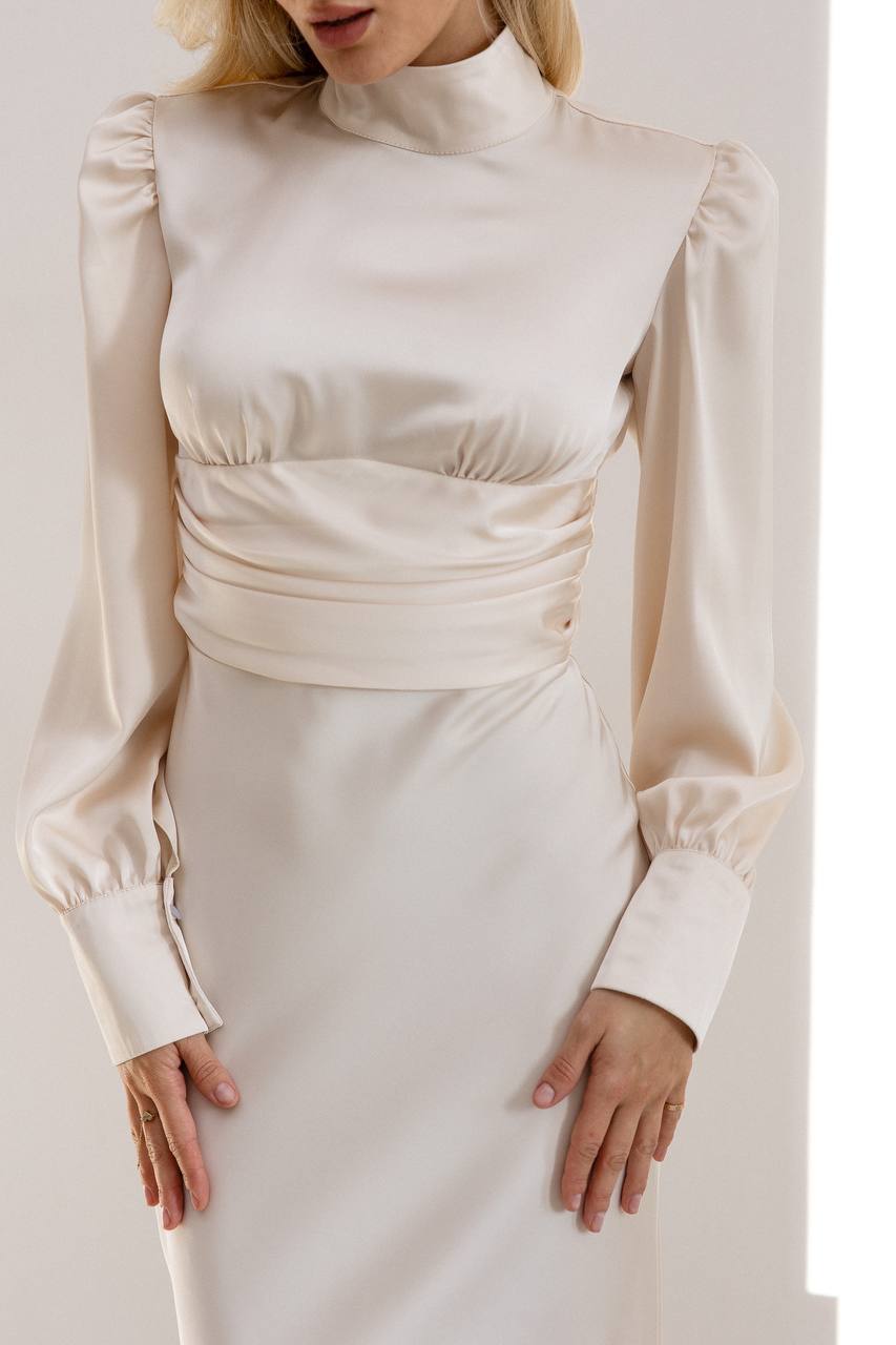 Beige long-sleeve top and skirt set on a plain background