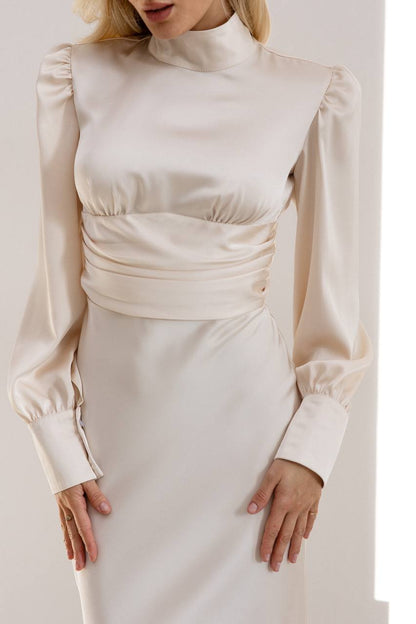 Beige long-sleeve top and skirt set on a plain background