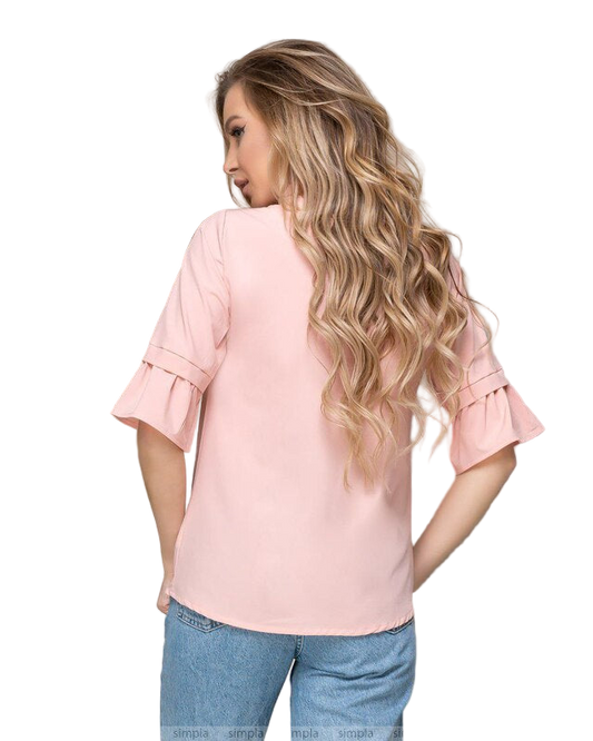 Woman wearing a pink blouse with ruffled sleeves on a white background