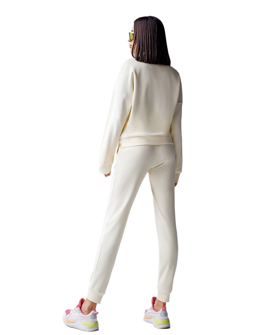 Person wearing a white tracksuit with colorful sneakers on a white background