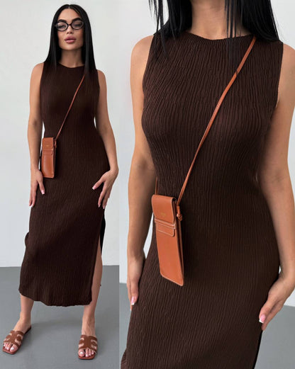 Woman wearing a brown dress with a brown crossbody bag against a white background