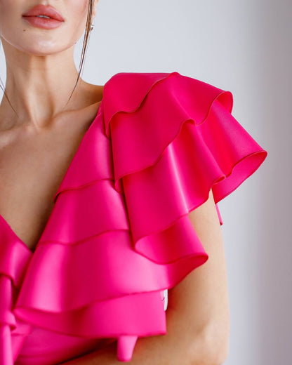 Close-up of a bright pink ruffled top on a blurred background
