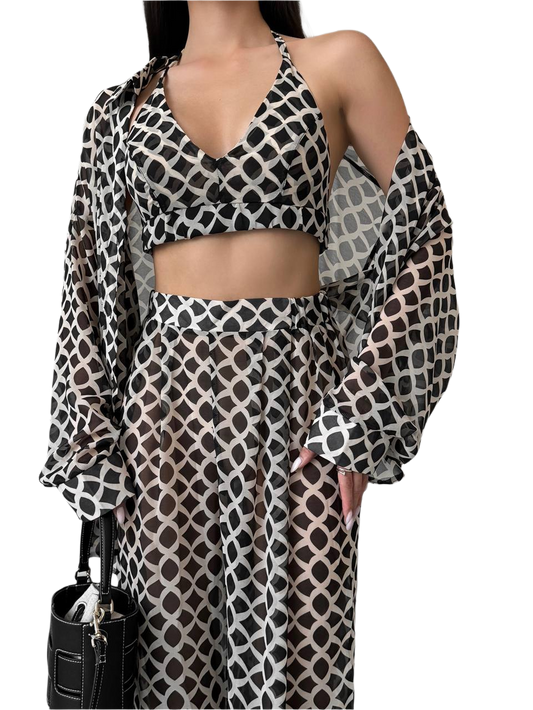 Woman wearing a patterned outfit with a black handbag on a white background