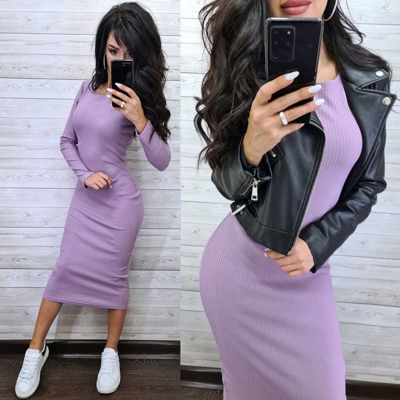 Woman taking a mirror selfie wearing a purple dress and black leather jacket.